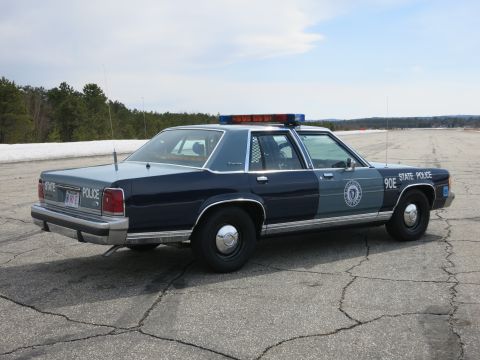 1991 Ford LTD Crown Victoria - Side view of a two-tone blue Ford LTD Crown Victoria State Police cruiser marked 90E STATE POLICE with door seal.