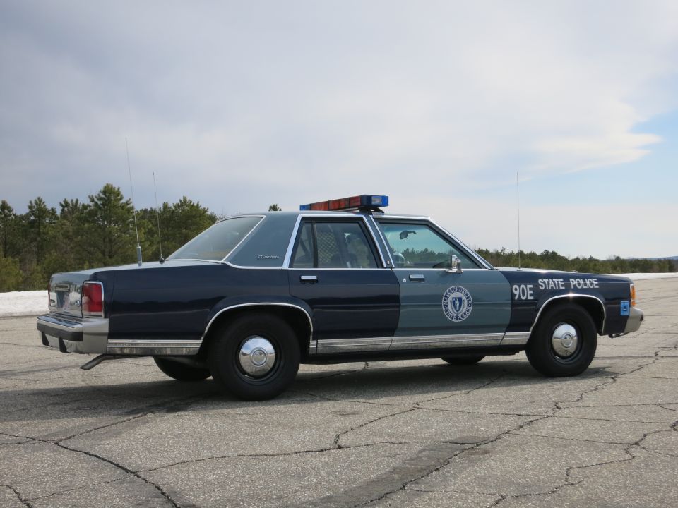 Right side profile of dark blue Ford Crown Victoria State Police cruiser 90E