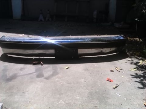 1992 Ford Bronco - A detached front bumper is shown on a concrete surface, with debris scattered around.