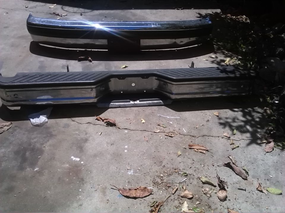 Two chrome bumpers, one with a black plastic step pad