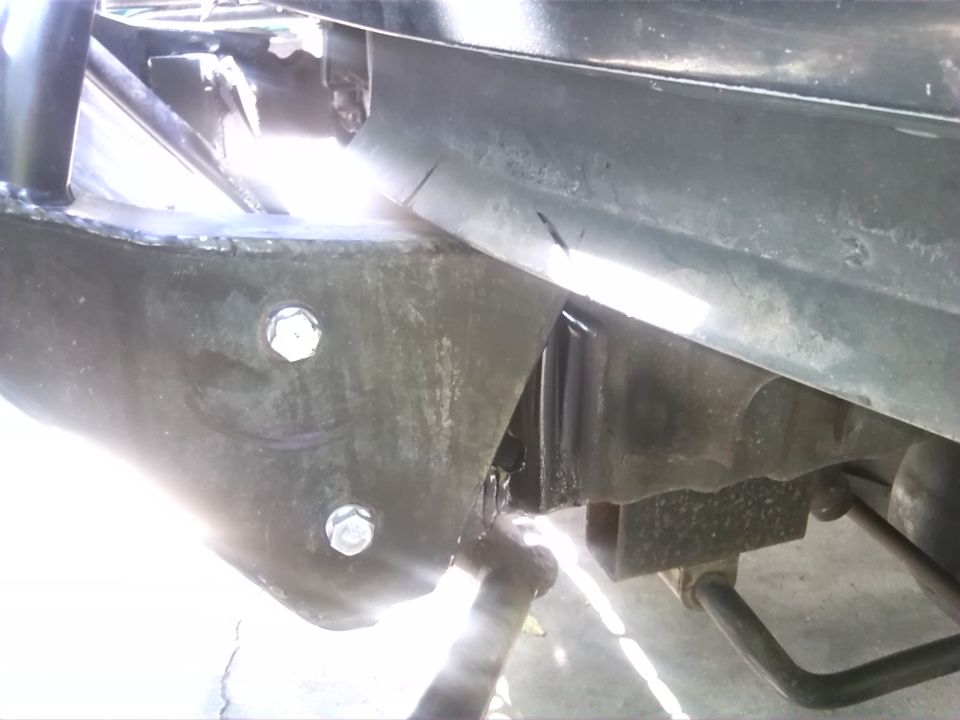 Close-up of vehicle frame with bolts and suspension parts visible