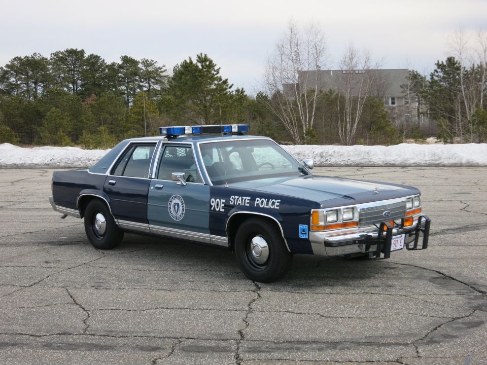 Blue State Police sedan front three-quarter, Ford grille, red plate 90 E
