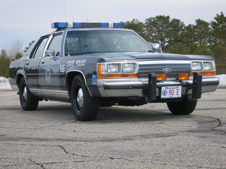 Massachusetts State Police Ford cruiser, front right view, trees behind