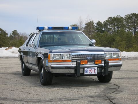 1991 Ford LTD Crown Victoria - Massachusetts State Police Ford LTD Crown Victoria with chrome grille and brush guard, shot from a low front-right angle.