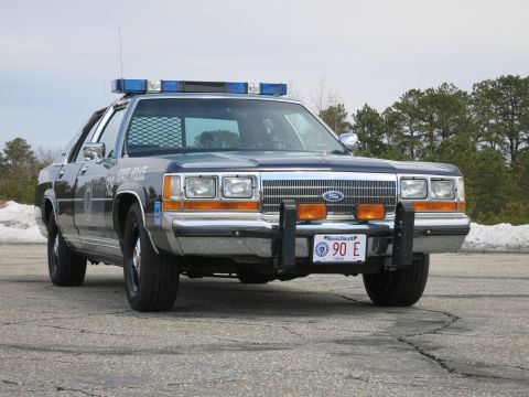 1991 Ford LTD Crown Victoria - Massachusetts State Police Ford LTD Crown Victoria with chrome grille and push bar, photographed front-right on pavement.
