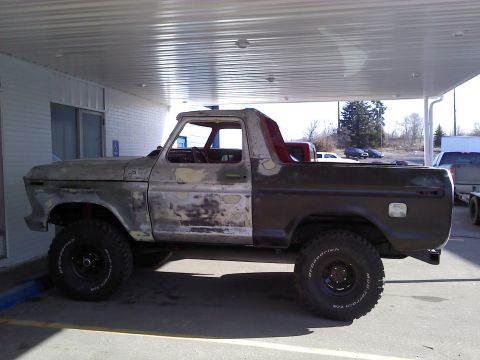 1978 Ford Bronco - This vintage Ford Bronco is undergoing restoration, with visible primer and rust patches on its body.
