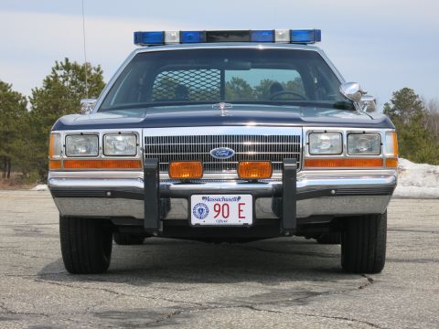1991 Ford LTD Crown Victoria - two-tone blue Massachusetts State Police Ford LTD Crown Victoria viewed head-on with chrome grille and push bumper.