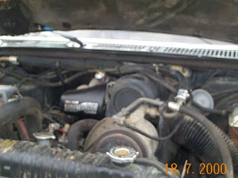 1986 Ford F-250 - The engine bay of a truck is visible, with various hoses and mechanical parts.