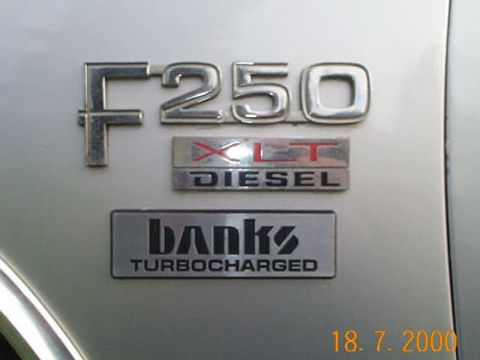 1986 Ford F-250 - Close-up of F250 XLT DIESEL and Banks TURBOCHARGED badges on a vehicle's exterior.