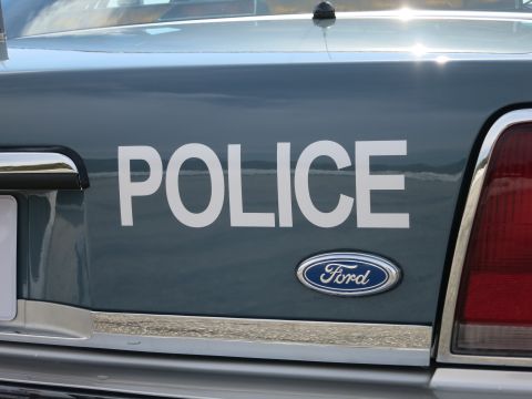 1991 Ford LTD Crown Victoria - Dark gray rear quarter panel of a police car with POLICE lettering and a blue Ford oval badge beside the taillight.