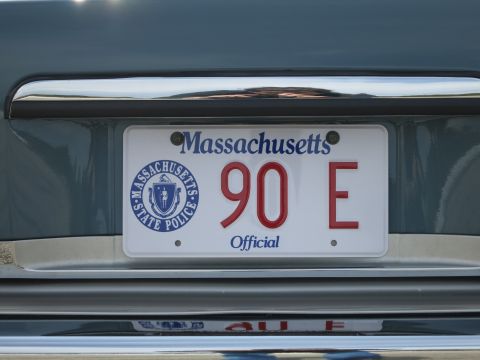 1991 Ford LTD Crown Victoria - Close-up of a Massachusetts Official license plate reading 90 E with a Massachusetts State Police seal at left.
