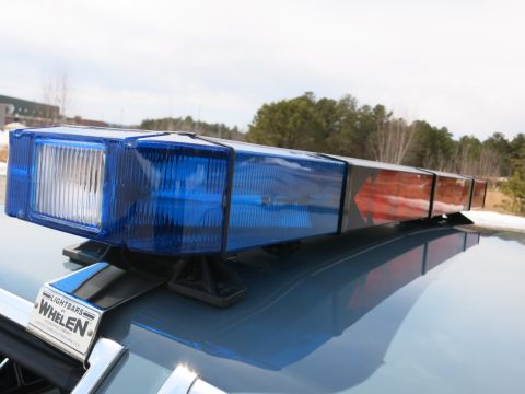 1991 Ford LTD Crown Victoria - Blue and amber Whelen roof lightbar mounted on a police car, with a Whelen Lightbars decal on the trunk below.
