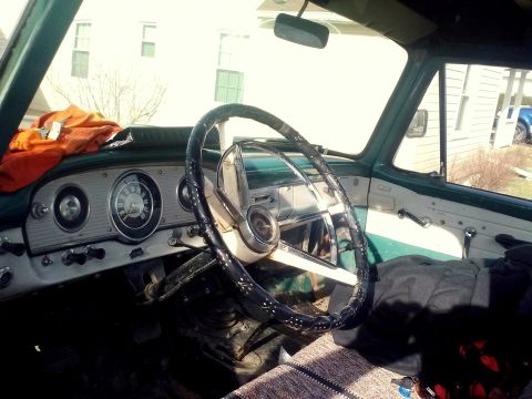 1963 Ford F-100 - The dashboard and steering wheel of a 1961 Ford F-100 truck are visible from the interior.