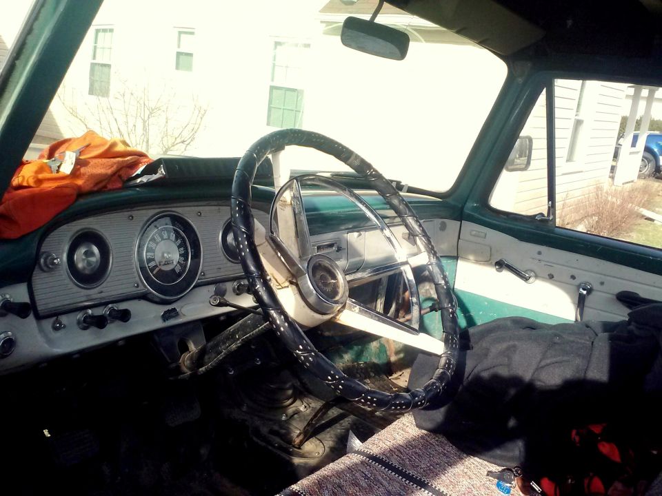 Green and white interior of a 1961 Ford F-100 truck, showing the dashboard and steering wheel