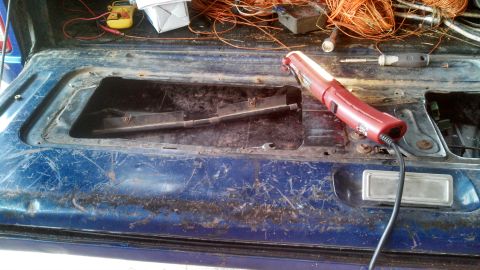 1979 Ford Bronco - The interior of a blue tailgate is shown with various tools and wiring, indicating a state of disrepair.