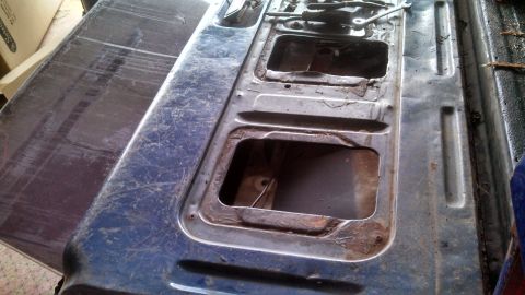 1979 Ford Bronco - The tailgate of a 1979 Ford Bronco is shown with its interior structure exposed, revealing signs of rust.