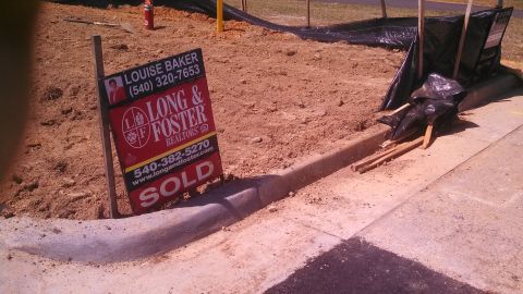1979 Ford Bronco - A 'Sold' sign is planted in the dirt next to a curb.