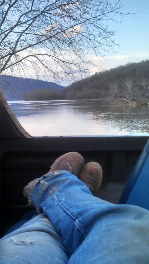 1979 Ford Bronco - Relaxing view from inside a vehicle, overlooking a wide river and tree-covered hills under a partly cloudy sky.
