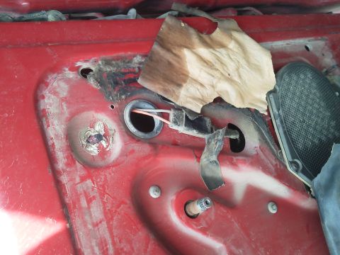 1979 Ford F-150 - Close-up of exposed wiring and a torn piece of paper on a red interior door panel.
