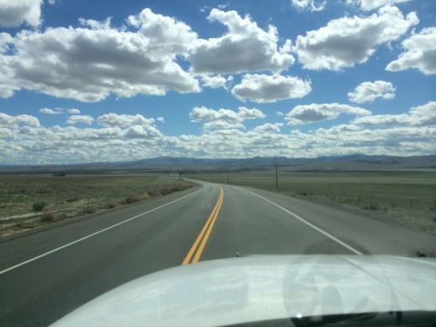 1996 Ford C-350 (Centurion Conversions) - A view from inside a vehicle driving on a highway through a vast, open landscape under a cloudy sky.