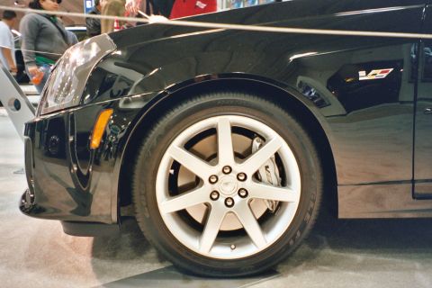 1992 Mercury Grand Marquis - A black Cadillac CTS-V is viewed from the front quarter, highlighting its distinctive fender and wheel design.