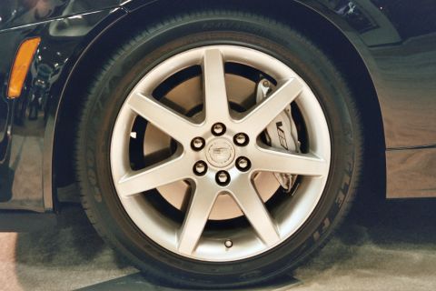 1992 Mercury Grand Marquis - Close-up of a silver 5-spoke wheel and a V-series brake caliper on a black vehicle.