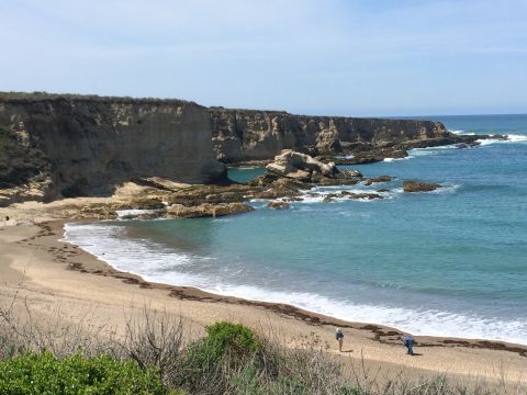 1996 Ford C-350 (Centurion Conversions) - A scenic view of a beach with cliffs and the ocean on a clear day.