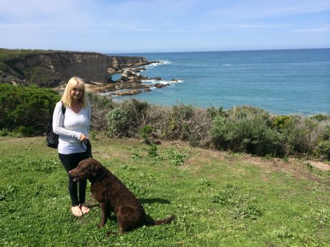 1996 Ford C-350 (Centurion Conversions) - A woman and her dog enjoy a scenic view of the ocean and rocky coastline.