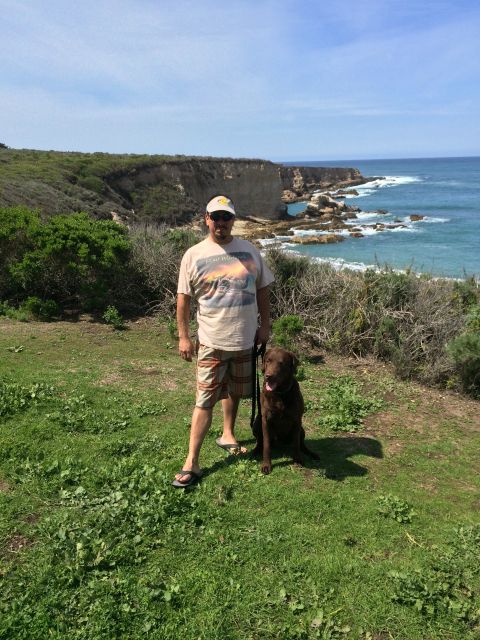 1996 Ford C-350 (Centurion Conversions) - A man and his dog enjoy a scenic view of the coastline.