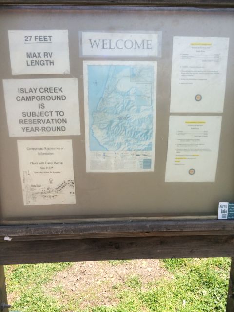 1996 Ford C-350 (Centurion Conversions) - Campground bulletin board displays rules, a map, and registration details for visitors.