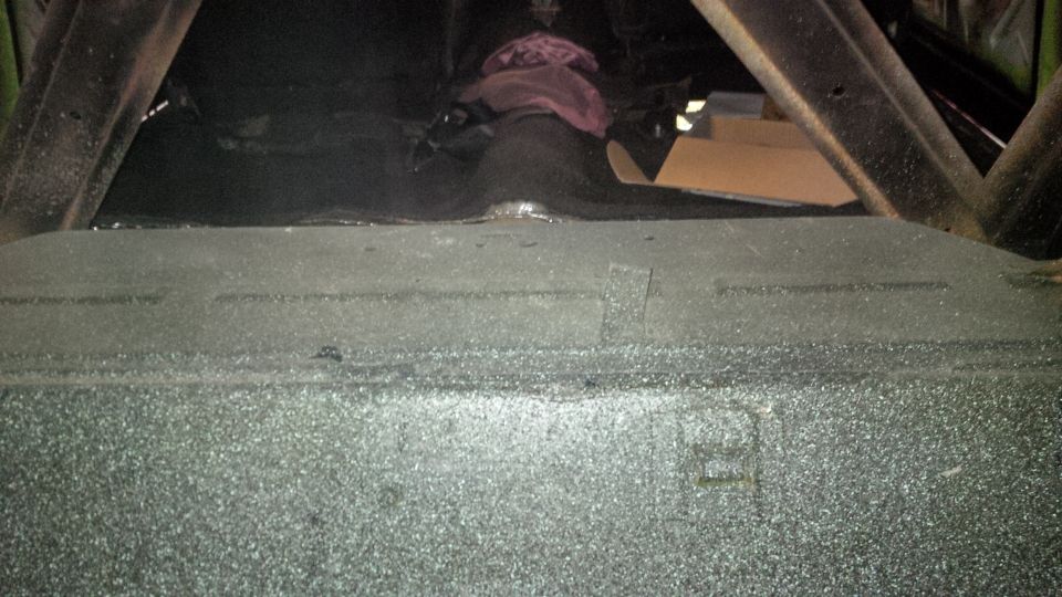 Car trunk interior with visible metal bracing and some stored items