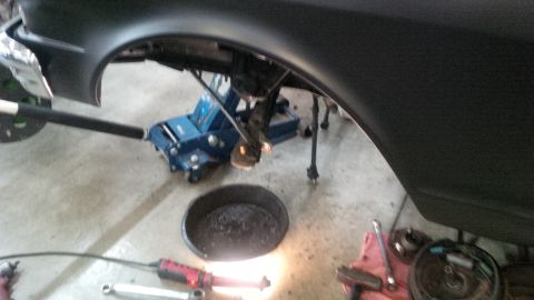 1963 Chevrolet Nova - A car part is being worked on, with a jack, tools, and an oil pan visible.