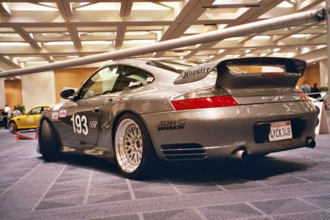 1992 Mercury Grand Marquis - A modified Porsche 911 GT2 with racing numbers and sponsor decals is displayed indoors.