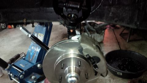 1963 Chevrolet Nova - A car's brake system is shown while being serviced, with the wheel removed and the vehicle supported by jack stands.