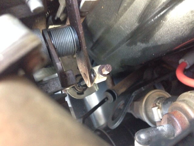 Throttle linkage mechanism with a coiled spring and metal levers, close-up view