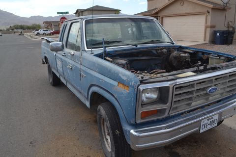 1981 Ford F-250 - This 1981 Ford F-250 pickup truck is parked on a residential street with its hood open.