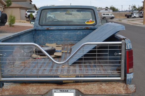 1981 Ford F-250 - This 1981 Ford F-250 pickup truck is seen from the rear, showing its bed equipped with a metal rack and a spare tire.