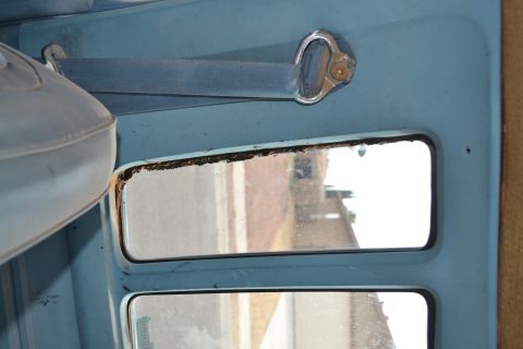 1981 Ford F-250 - Close-up of a vehicle's interior door panel and window, showing the seat and reflection in the glass.