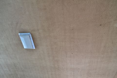 1981 Ford F-250 - A single chrome trim piece is visible against a textured tan background.