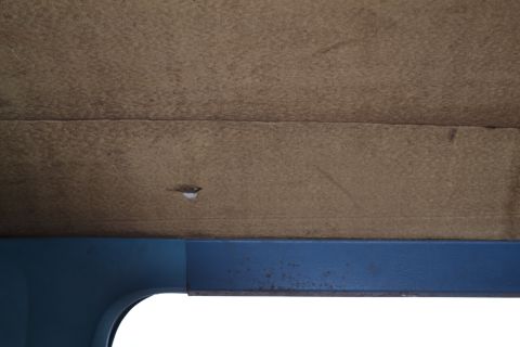 1981 Ford F-250 - Interior view of a vehicle's headliner and upper door frame, showing textured material and painted metal.