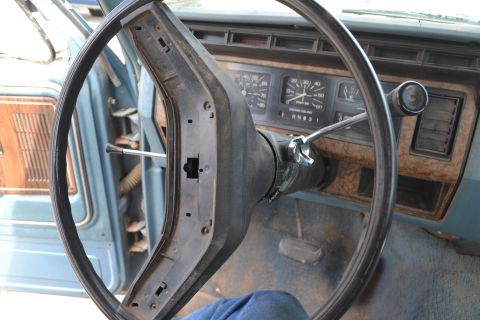 1981 Ford F-250 - The dashboard of a truck shows a steering wheel and instrument cluster, with wood-grain trim visible.