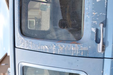 1981 Ford F-250 - Detail of a weathered blue truck door, showing signs of age and wear.