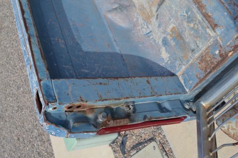 1981 Ford F-250 - The rear corner of a weathered truck bed shows signs of rust and wear around the taillight assembly.