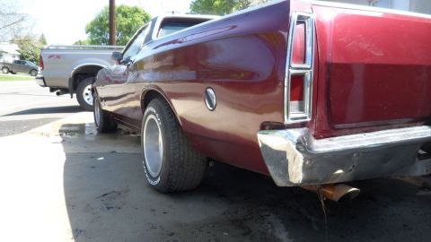 1972 Ford Ranchero - The rear of a red 1972 Ford Ranchero is shown parked next to a silver pickup truck.