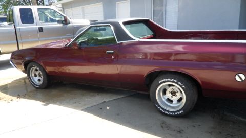 1972 Ford Ranchero - Side view of a maroon 1972 Ford Ranchero with a black top, parked on a concrete driveway.