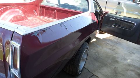 1972 Ford Ranchero - Rear view of a 1972 Ford Ranchero pickup, driver's door ajar, with another vehicle visible in the background.
