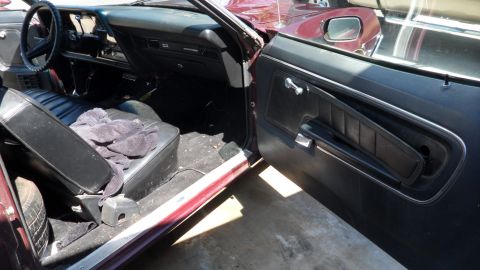 1972 Ford Ranchero - Interior view of a maroon 1972 Ford Ranchero, showing the dashboard, seats, and door panel.