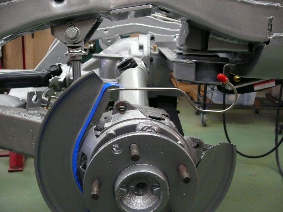 Close-up of car's suspension and brake assembly with Supermotors logo