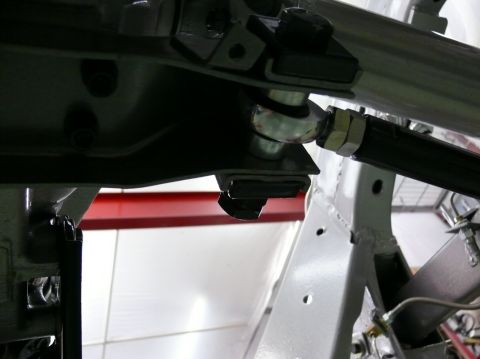 Close-up of a car's suspension linkage with a ball joint and adjustment sleeve