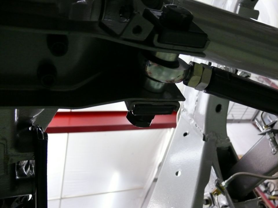 Close-up of a car's suspension linkage with a ball joint and adjustment sleeve